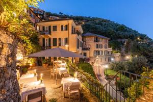 een restaurant met tafels en een paraplu voor een gebouw bij Hotel Piccolo Portofino in Portofino