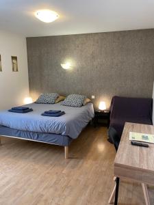 ein Hotelzimmer mit zwei Betten und einem Tisch in der Unterkunft Chambres d'hôtes de l'Auberge L'Astrassadou in Rézentières