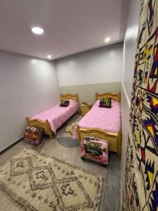 2 letti in una camera con tappeto di Sweet and Simple a Oujda