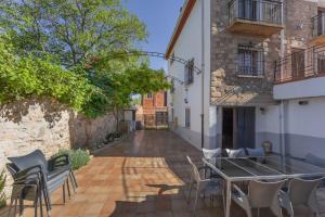 eine Terrasse mit einem Tisch und Stühlen neben einem Gebäude in der Unterkunft La Herreria de Esteban in Cuevas Labradas