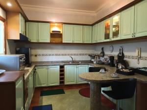 una cucina con armadi verdi e un tavolo di Villa stade Moulay Abdellah a Temara Altre 47 foto