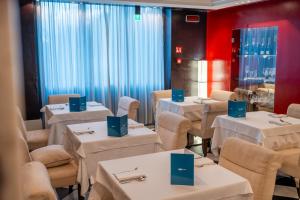 een restaurant met witte tafels en stoelen met blauwe dozen erop bij Hotel Piccolo Portofino in Portofino +59 foto's