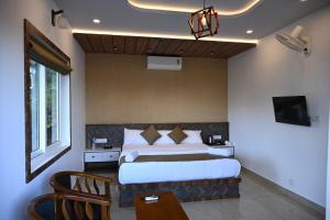 een slaapkamer met een bed en een tv erin bij Banasura Cradle Premium Pool Resort in Wayanad