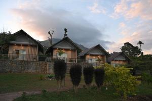 una hilera de casas con árboles delante de ellas en Banasura Cradle Premium Pool Resort, en Wayanad