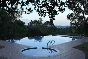 een zwembad met een reflectie in het water bij Banasura Cradle Premium Pool Resort in Wayanad