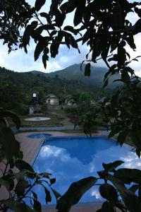 een blauw zwembad met bergen op de achtergrond bij Banasura Cradle Premium Pool Resort in Wayanad