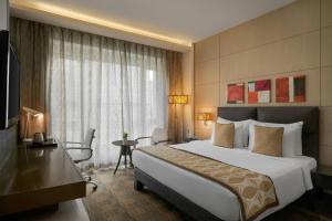 a hotel room with a large bed and a desk at Meluha The Fern Mumbai, Powai, Series by Marriott in Mumbai +14 photos