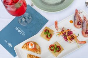 a plate of food on a table with a book at Hotel Piccolo Portofino in Portofino
