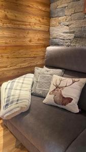 a couch with two pillows and a deer pillow on it at Il fienile in Valfurva