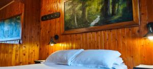 een slaapkamer met een bed en een schilderij aan de muur bij Chalé de montaña con Jacuzzi in Guarne