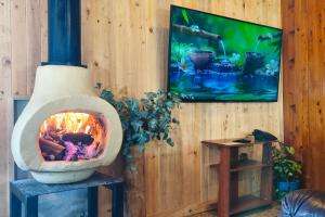 een open haard in een houten wand met een schilderij bij Chalé de montaña con Jacuzzi in Guarne