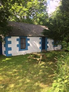 een blauw-wit huis met een picknicktafel in de tuin bij Pond Cottage in Covington