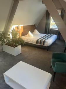 une chambre avec un lit, un canapé et une chaise dans l'établissement Hôtel des Rochers, à Perros-Guirec