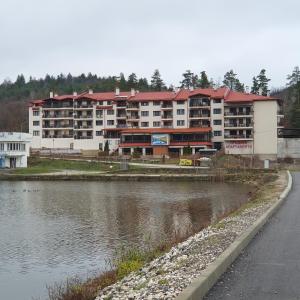 ein großes Apartmenthaus neben einem Wasserkörper in der Unterkunft Lake View Deluxe Tryavna in Trjawna
