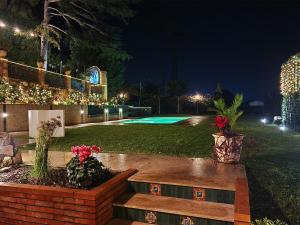 een achtertuin 's nachts met een zwembad en verlichting bij Villa Tommaso Maruggi, Sicilia, con Jacuzzi e piscina privata in Alcamo