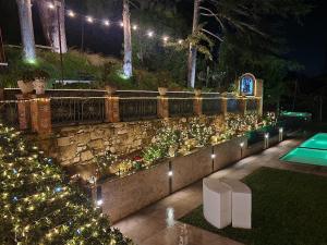 een tuin met kerstverlichting en een stenen muur bij Villa Tommaso Maruggi, Sicilia, con Jacuzzi e piscina privata in Alcamo