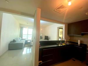 een keuken en een woonkamer met een bank bij Exclusive Sea-View 2BR Apartment with Fireworks View in New-year eve in Abu Dhabi
