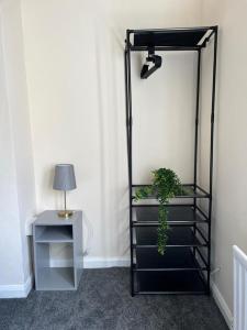 een zwarte plank met een potplant naast een tafel bij Tyneside Two Bedroom Apart in Gateshead