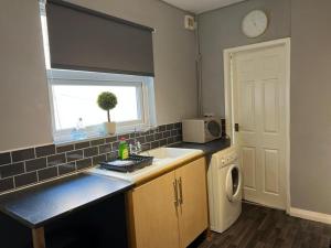 een keuken met een spoelbak en een wasmachine bij Tyneside Two Bedroom Apart in Gateshead