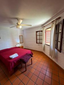 ein Schlafzimmer mit einem roten Bett und einem Fenster in der Unterkunft El Amanecer in Mina Clavero + 3 Fotos