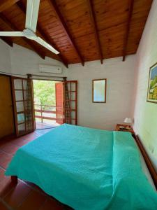 ein Schlafzimmer mit einem großen blauen Bett in einem Zimmer in der Unterkunft El Amanecer in Mina Clavero