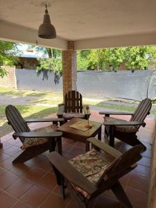 eine Terrasse mit zwei Stühlen und einem Holztisch und Stühlen in der Unterkunft El Amanecer in Mina Clavero