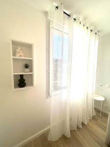 a room with a window with white curtains at Studio cosy refait à neuf - Parking privé in Lanester