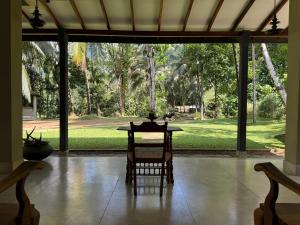 a table with two chairs and a view of a yard at Cinnamonhouse Villa in Poregedara