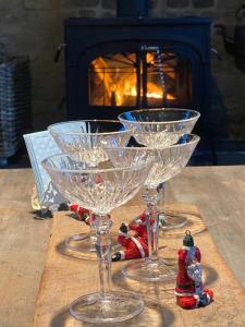 three wine glasses sitting on a table in front of a fireplace at Eikenbrand in Veurne
