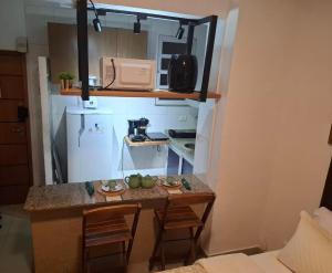 a small kitchen with a table with chairs and a refrigerator at Studio Lapa in Rio de Janeiro +4 photos