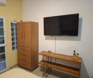 a flat screen tv hanging on a wall with a desk at Studio Lapa in Rio de Janeiro