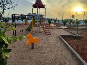 a playground with a swing set and a play structure at Next Nest in Gannavaram