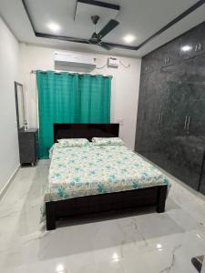 a bedroom with a bed and a green curtain at Next Nest in Gannavaram
