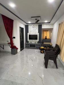 a living room with a tv and a couch at Next Nest in Gannavaram +12 photos