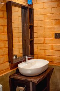 a bathroom with a white sink and a mirror at Rainforest Royal Heritage in Deniyaya