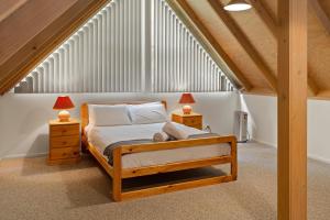 a bedroom with a bed and two lamps in a attic at Settle @ Sawmill in Mount Buller