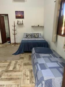 een slaapkamer met twee bedden en een houten vloer bij Chalé Mirante do Lago Cotijuba in Belém +12 foto's