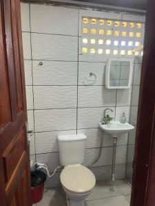 een kleine badkamer met toilet en wastafel bij Chalé Mirante do Lago Cotijuba in Belém