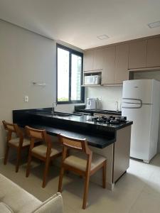 een keuken met een zwart aanrecht en een witte koelkast bij Apartamento moderno no Horto in Ipatinga