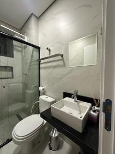 een badkamer met een wastafel, een toilet en een douche bij Apartamento moderno no Horto in Ipatinga