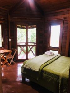 a bedroom with a bed in a room with windows at Refugioecolodge in Nova Friburgo