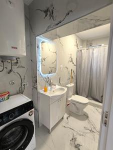een badkamer met toilet, wastafel en wasmachine bij Nar in Budva