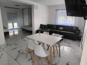een woonkamer met een witte tafel en stoelen bij Nar in Budva