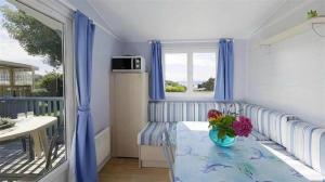 ein Zimmer mit einem Tisch mit einer Blumenvase darauf in der Unterkunft Camping 4 étoiles - Piscine - ccbegca in Créach-Guennou