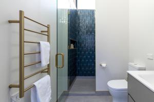 een badkamer met toilet en glazen douche bij Trails End - Architectually designed retreat in Punakaiki