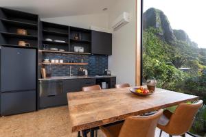 een keuken met een houten tafel en een groot raam bij Trails End - Architectually designed retreat in Punakaiki +5 foto's