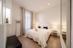 een slaapkamer met een wit bed en een groot raam bij Hyper centre Cannes - 2 pièces avec balcon - 4 couchages in Cannes