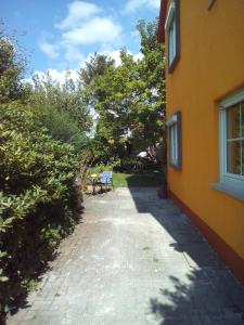 einen Gang neben einem gelben Gebäude mit einem Tisch in der Unterkunft Villa Walter in Leinfelden-Echterdingen