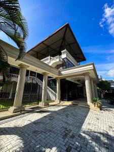 a large white building with columns and a porch at Dee Ella hotel in Danowita