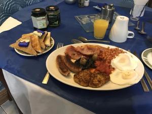 a blue table with a plate of breakfast food at Aquarius B&B in Newquay